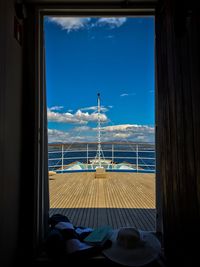 Close-up of sea against blue sky seen through doorway