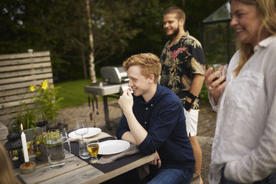 Happy friends having meal in garden