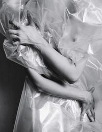 Midsection of woman wrapped in plastic