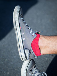 Low section of person with broken shoes on street