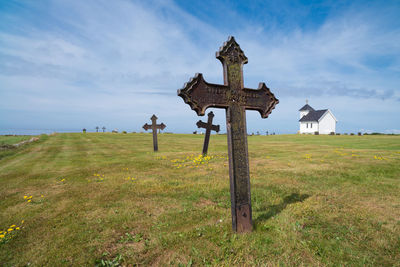 View of cross on field against sky