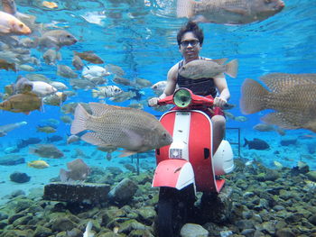 Young man with motor scooter undersea