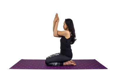 Woman with arms raised against white background