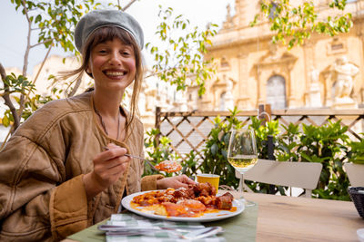 Portrait of young woman having food in restaurant