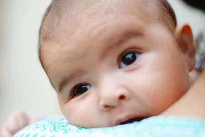 Close-up of baby looking away on bed