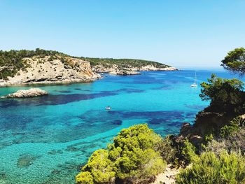 Scenic view of bay against clear blue sky