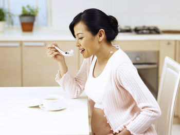 Young woman drinking coffee cup on table