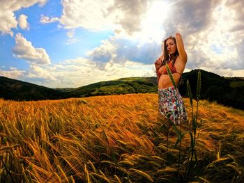 Woman standing on field against sky