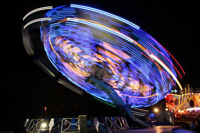 Low angle view of illuminated ferris wheel against sky at night