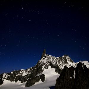 Scenic view of snowcapped mountain against sky at night