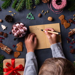 Cropped hands of boy writing on card