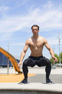Confident young man exercising during sunny day