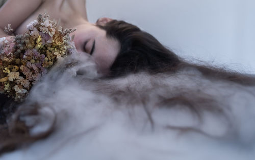 High angle view of young woman lying on snow