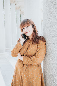 Young woman standing against wall