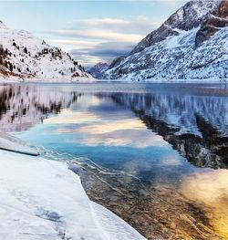 Calm lake against snow covered landscape