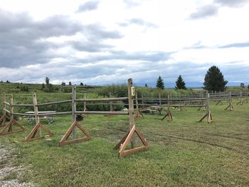 Wooden fence on field against sky