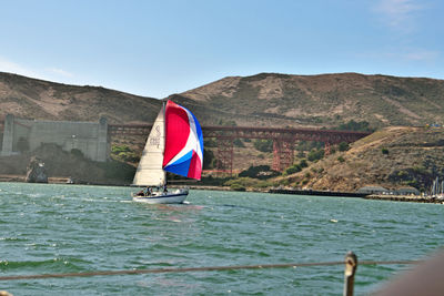 Sailboat sailing in sea against sky