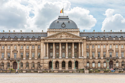 Facade of historical building against cloudy sky