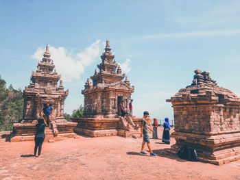 People at temple against sky