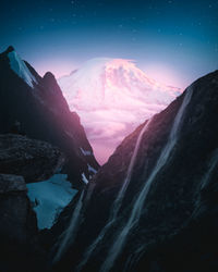 Scenic view of snowcapped mountains against sky at night