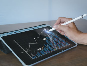 Cropped hands using mobile phone on table