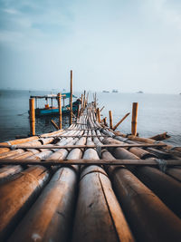 Wooden posts in sea against sky