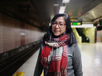 Portrait of woman standing at railroad station