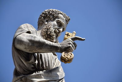 Low angle view of statue against clear blue sky