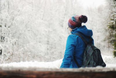 Midsection of person standing by tree during winter