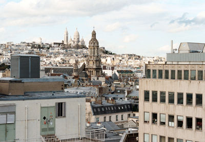 Buildings against cloudy sky