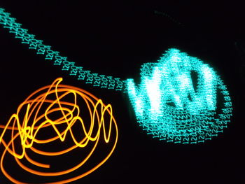 Close-up of illuminated lighting equipment against black background