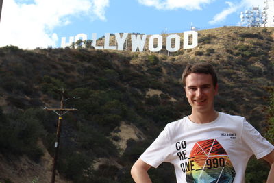 Portrait of smiling boy standing against sky