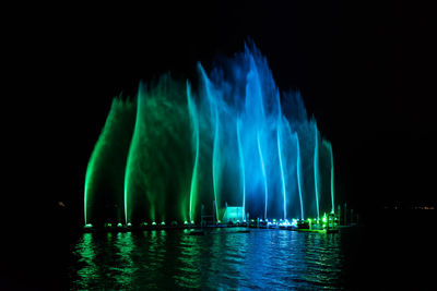 Illuminated fountain in sea at night