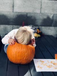 Cute girl with pumpkin sitting on floor