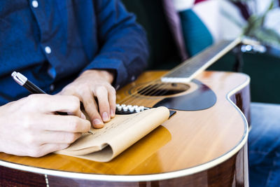 Midsection of man playing guitar