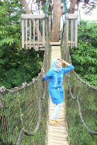 Full length of a girl standing on tree trunk