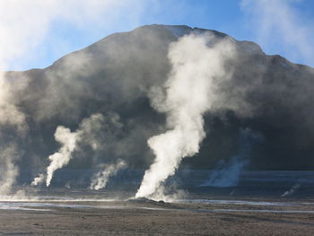 Smoke emitting from volcanic mountain against sky