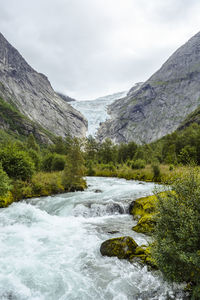 River flowing amidst mountains against sky