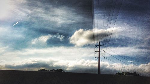 Low angle view of electricity pylon against sky