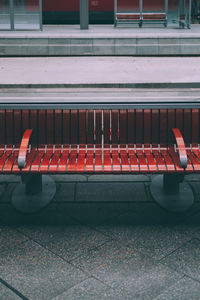 High angle view of empty red bench on footpath