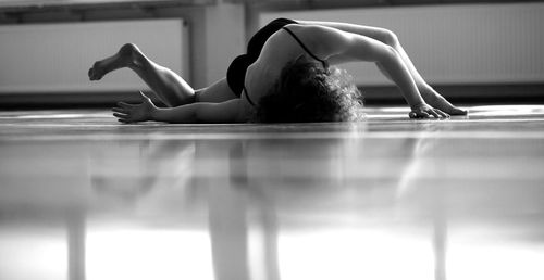 Low section of woman sitting on hardwood floor