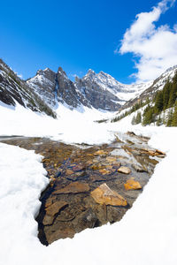 A break in the icea allows for a view of the crystal clear water of lake agnes.