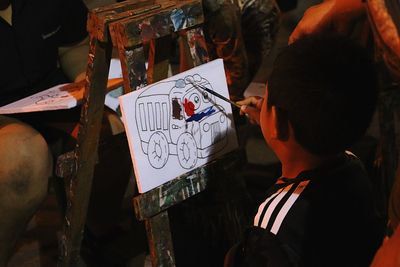 Rear view of boy painting at home