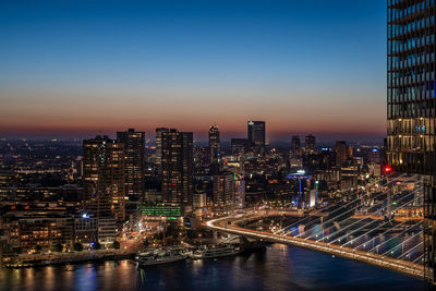 Illuminated buildings in city against sky at night