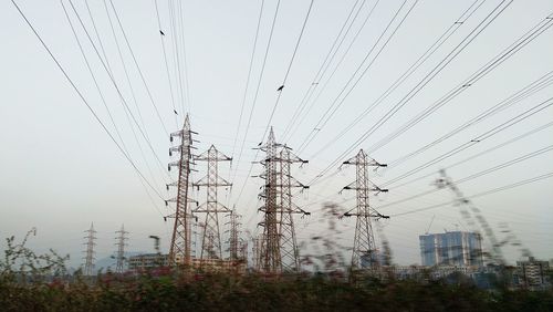 Low angle view of electricity pylon against clear sky