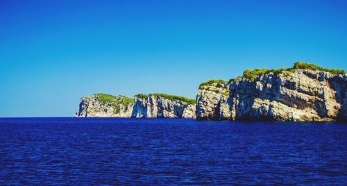 Scenic view of sea against clear blue sky