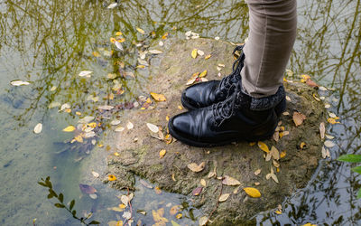 Low section of person standing on rock in water