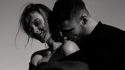 Close-up of young couple against gray background