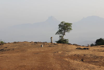 Man standing on mountain against clear sky