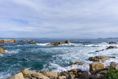 Scenic view of sea against sky. dark stones walk in san vicente do mar, o grove.